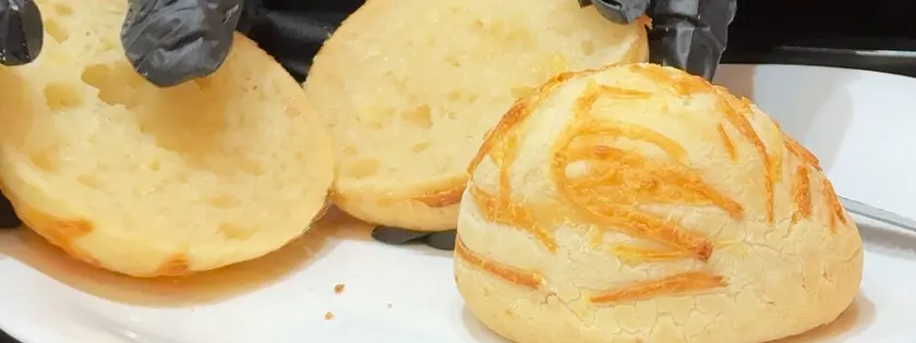 Pão de queijo aberto mostrando a textura leve por dentro