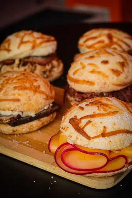 Pão de queijo recheado cortado mostrando o recheio